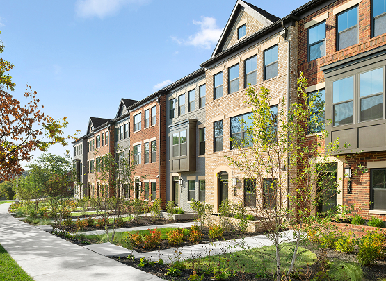 Row of modern multi-story NV Homes townhomes with red and beige brick facades