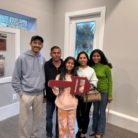 New homeowner posing in front of modern NVHomes property with