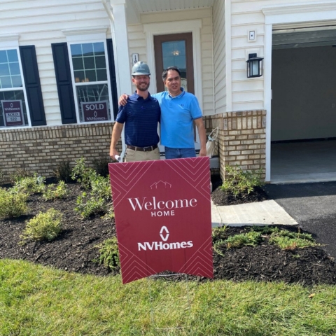 New homeowners posing in front of NVHomes property